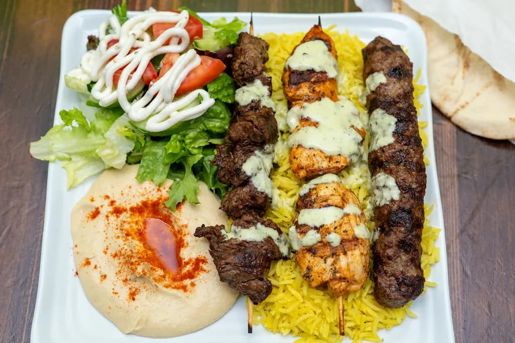 Mixed grill of beef, chicken and kafta kebabs with rice, hummus and salad